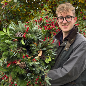 Wildly Traditional Christmas wreath featuring fresh evergreen foliage and natural festive decorations.